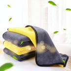 Gray and yellow microfiber towels with green leaves on a white background