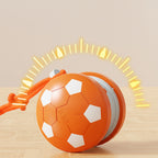 Orange ball with white hexagonal patterns and a rope on a beige background