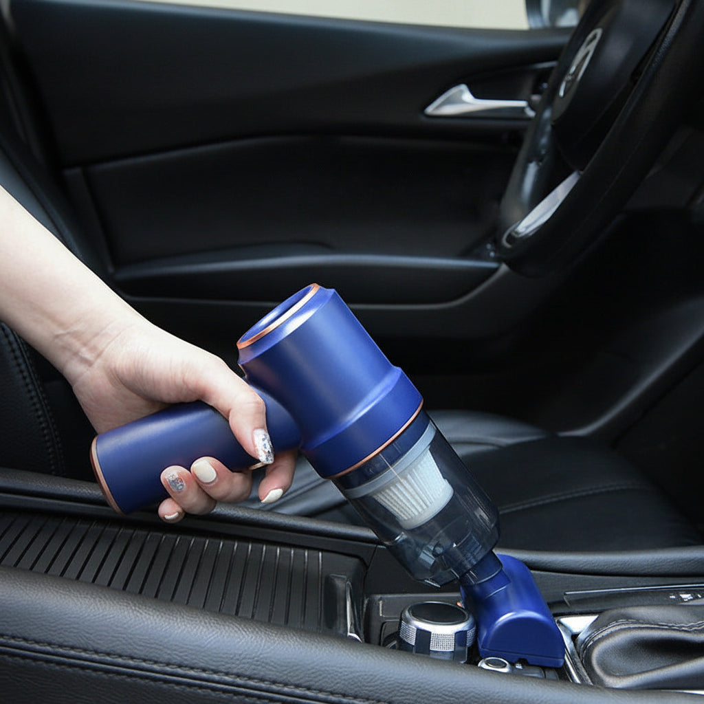 Hand holding a blue handheld vacuum cleaner inside a car.