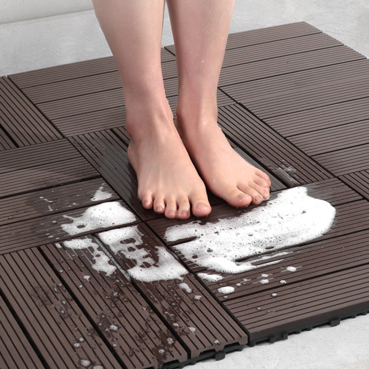 Person standing on a brown interlocking foam mat with soapy water splashes.