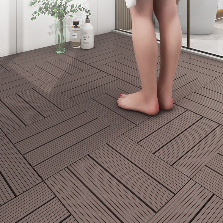 Wooden flooring tiles with a person standing on them, near a glass of water and bottles.